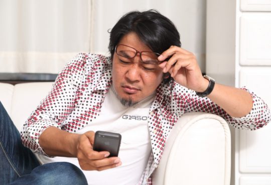 見にくそうにする男性